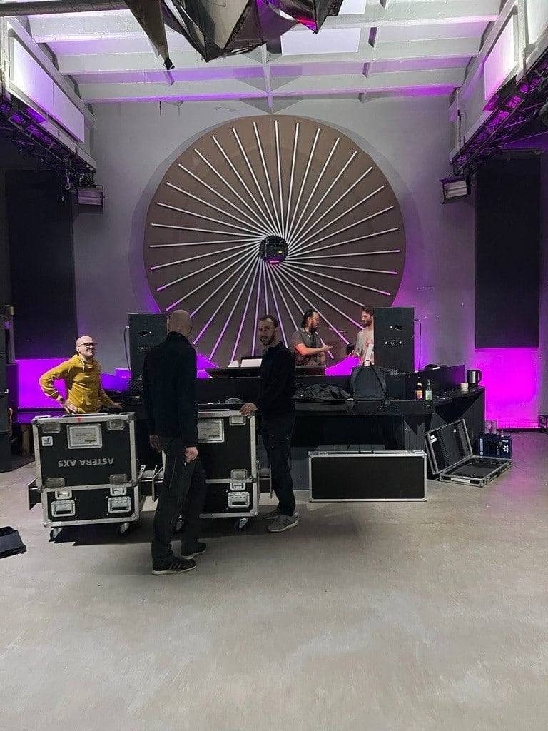 Das ARTFÊTE-Team beim Aufbau der Bühne — Flightcases, Licht und DJ-Setup in der rohen Halle vor der Nacht