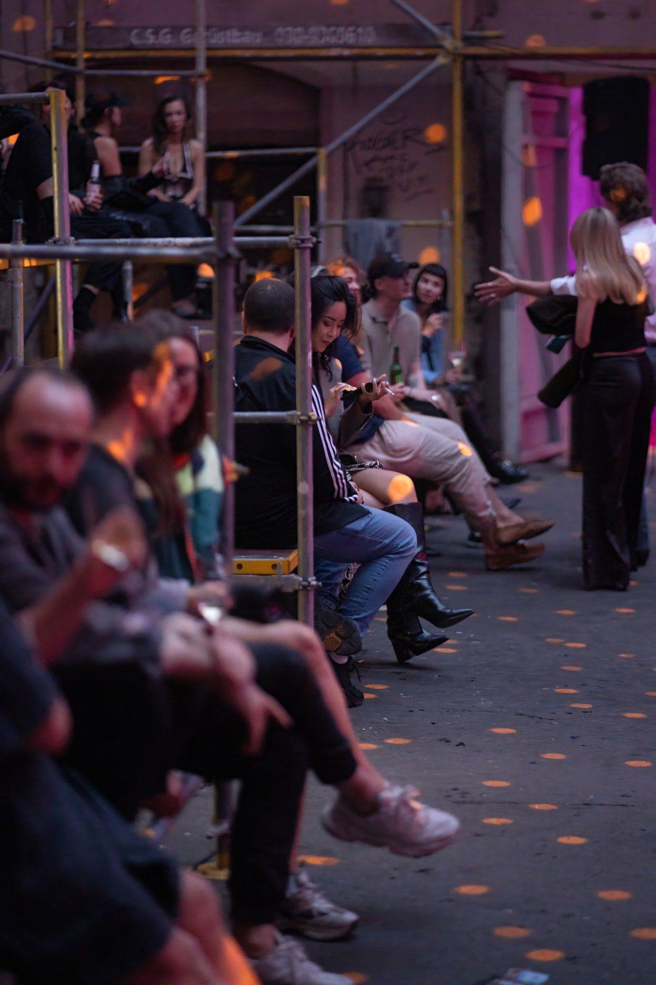 Der echte Bartresen im Service während einer ARTFETE-Nacht — Personal, beleuchtete Getränke, Gäste im violetten Licht